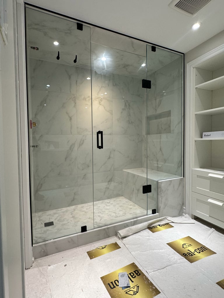 Modern bathroom with frameless glass shower enclosure featuring marble tile walls and built-in shelving with recessed lighting