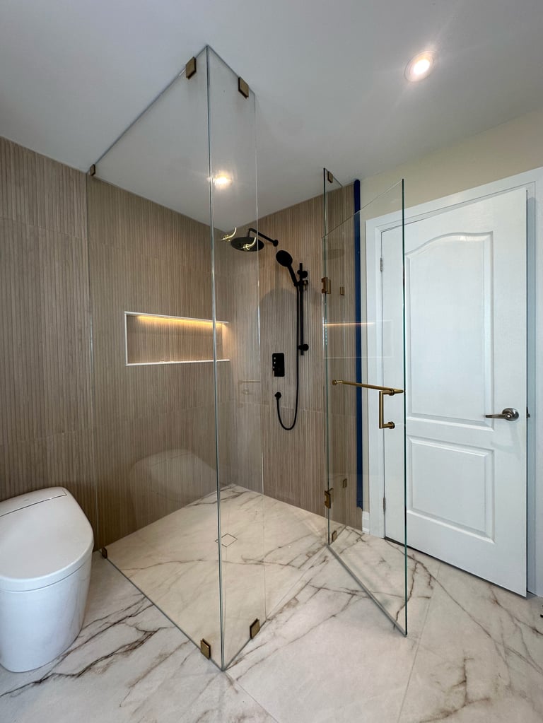 Modern bathroom with glass walk-in shower, marble flooring, wood-grain tile walls, white toilet, and recessed lighting